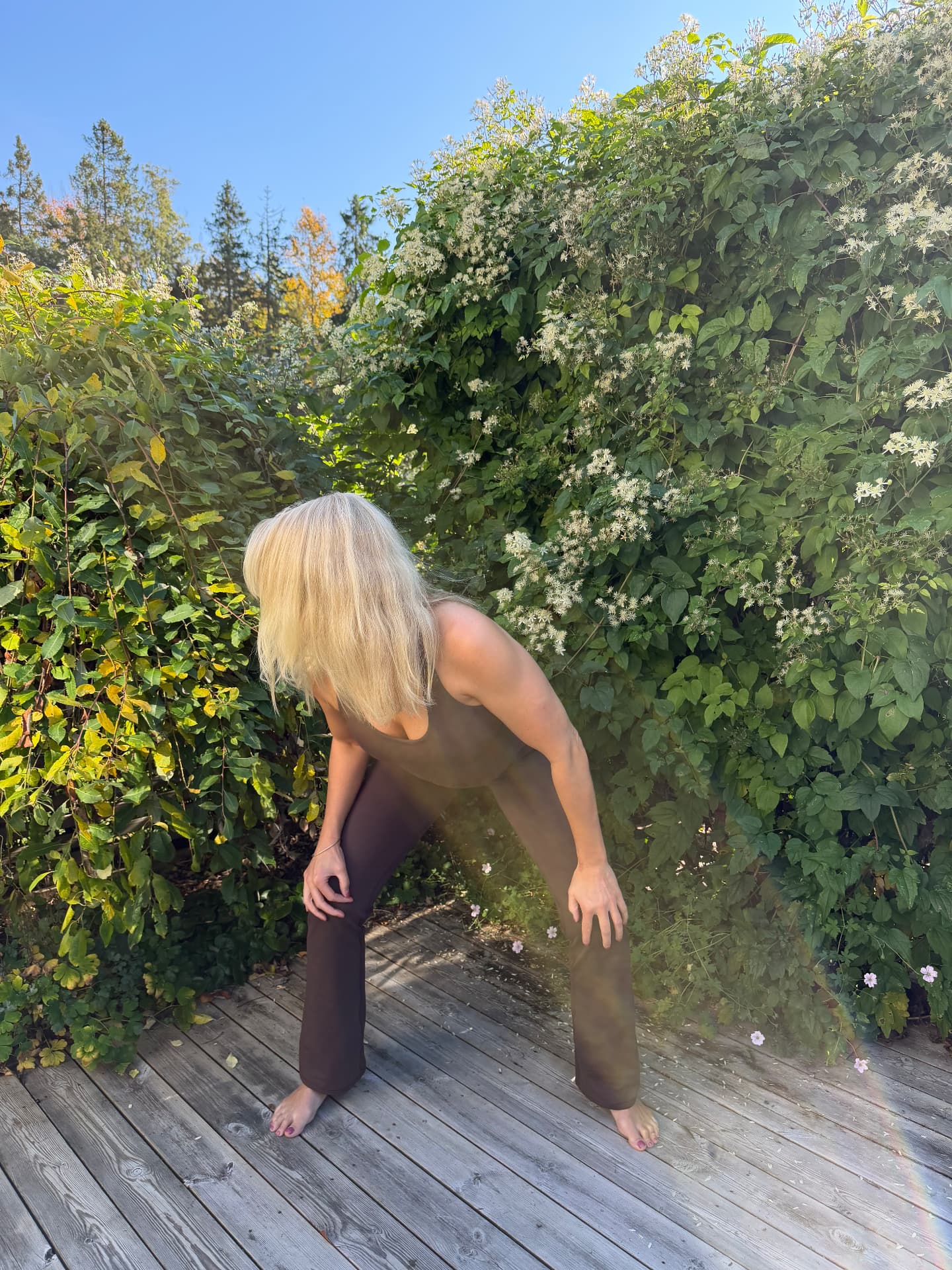 Johanna lutar sig framåt med händerna på knäna i qigong