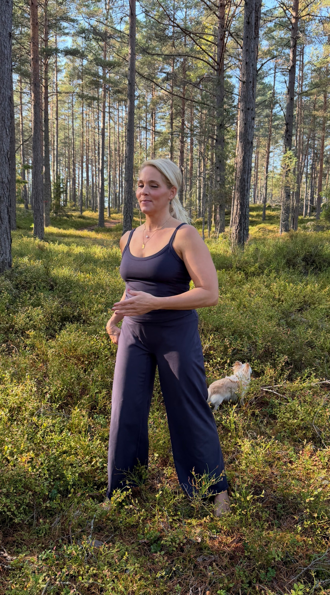 Johanna utövar qigong i en ljus tallskog